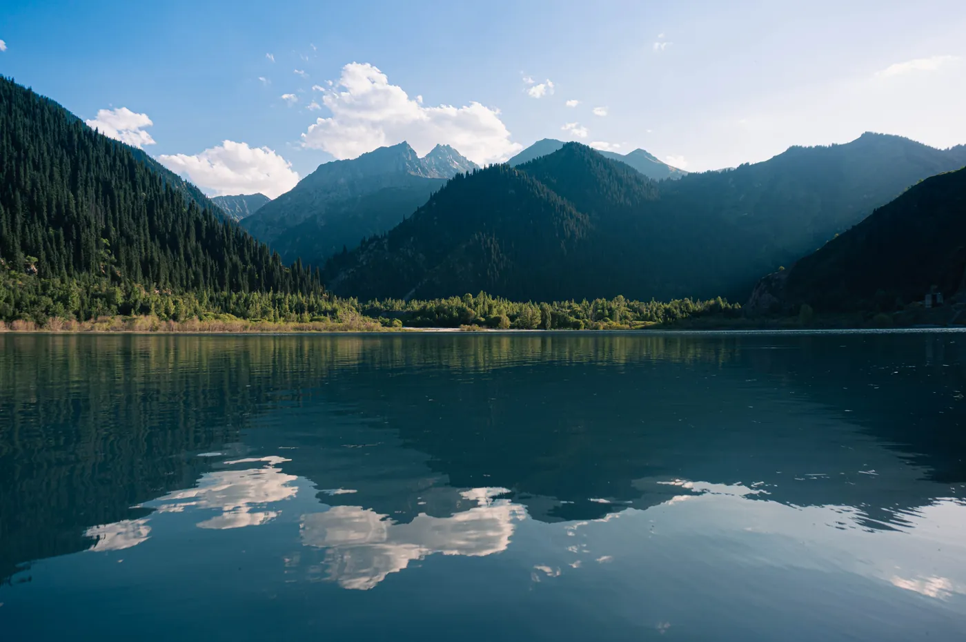 Lake Issyk reflecting the forested mountains